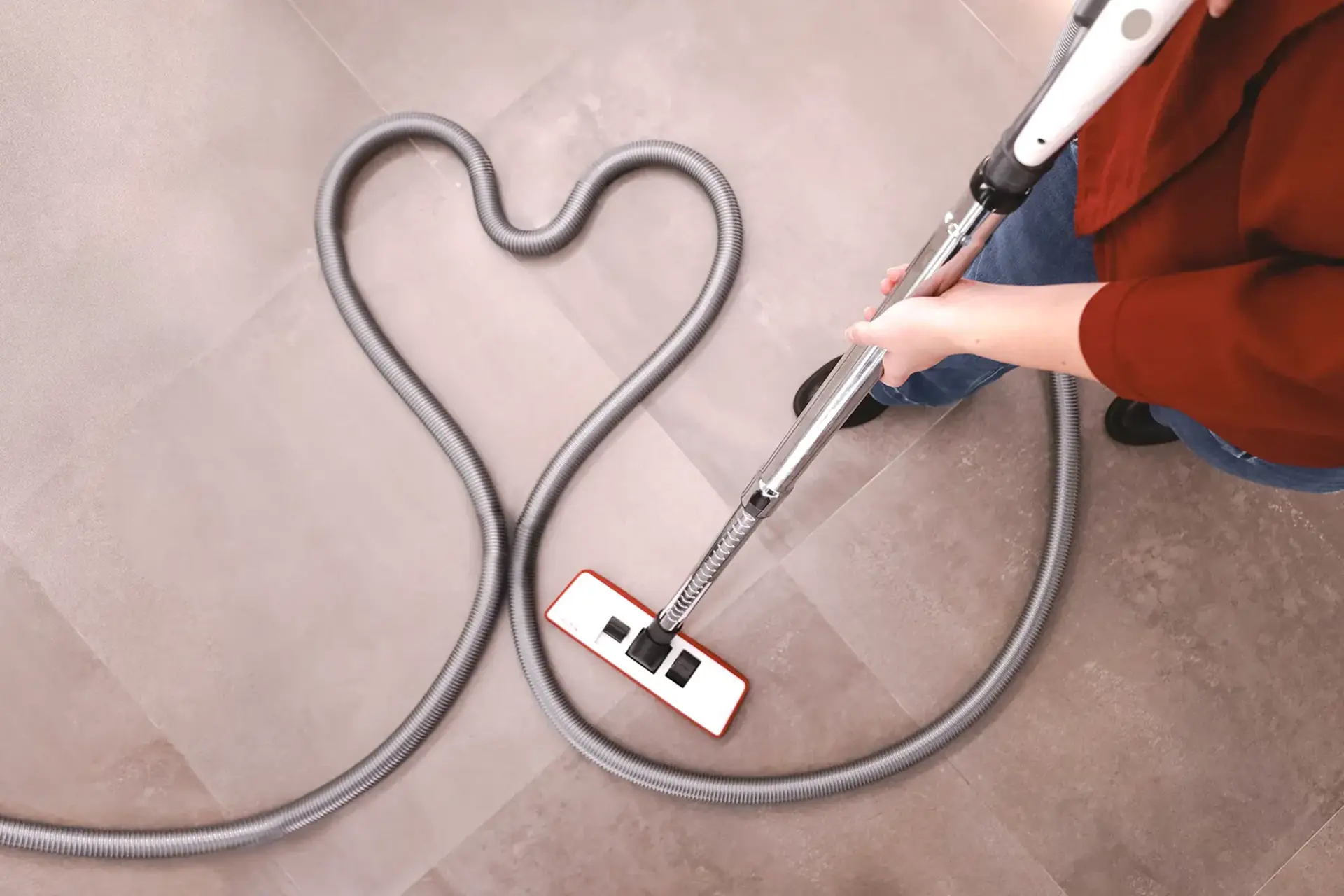 Wąż odkurzacza centralnego ułożony w kształt serca na podłodze – system centralny dla alergika